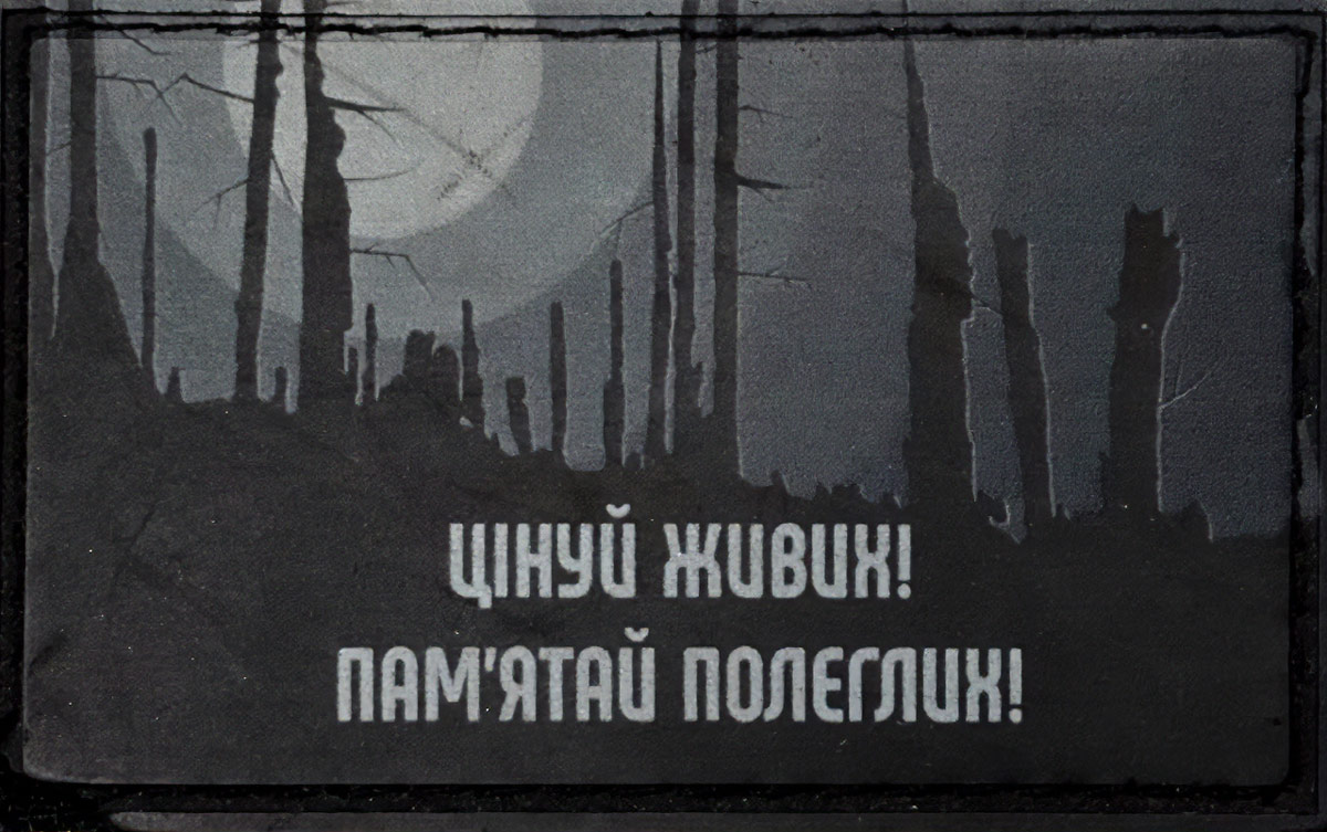 Нашивка нарукавна з зображенням випаленого чорного лісу на тлі сонця, що палає, із написом: “Цінуй живих! Пам’ятай полеглих”. З фондів Музею війни.